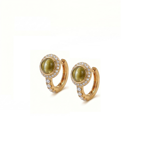 A pair of gold huggie hoop earrings featuring oval green cat's eye stones surrounded by a halo of small clear pavé stones, set against a plain white background.