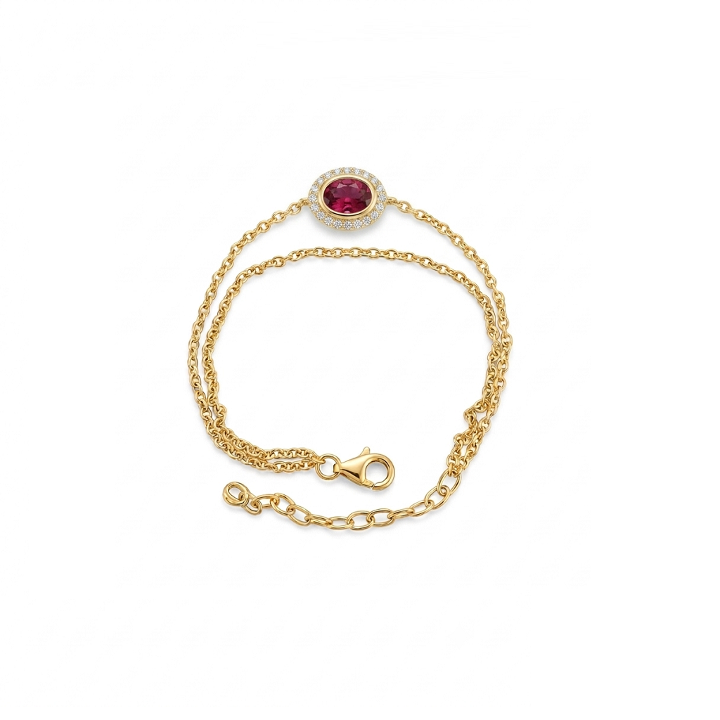 A delicate yellow gold chain bracelet featuring an oval-cut pinkish-red central stone surrounded by a halo of small clear stones, shown on a plain white background.